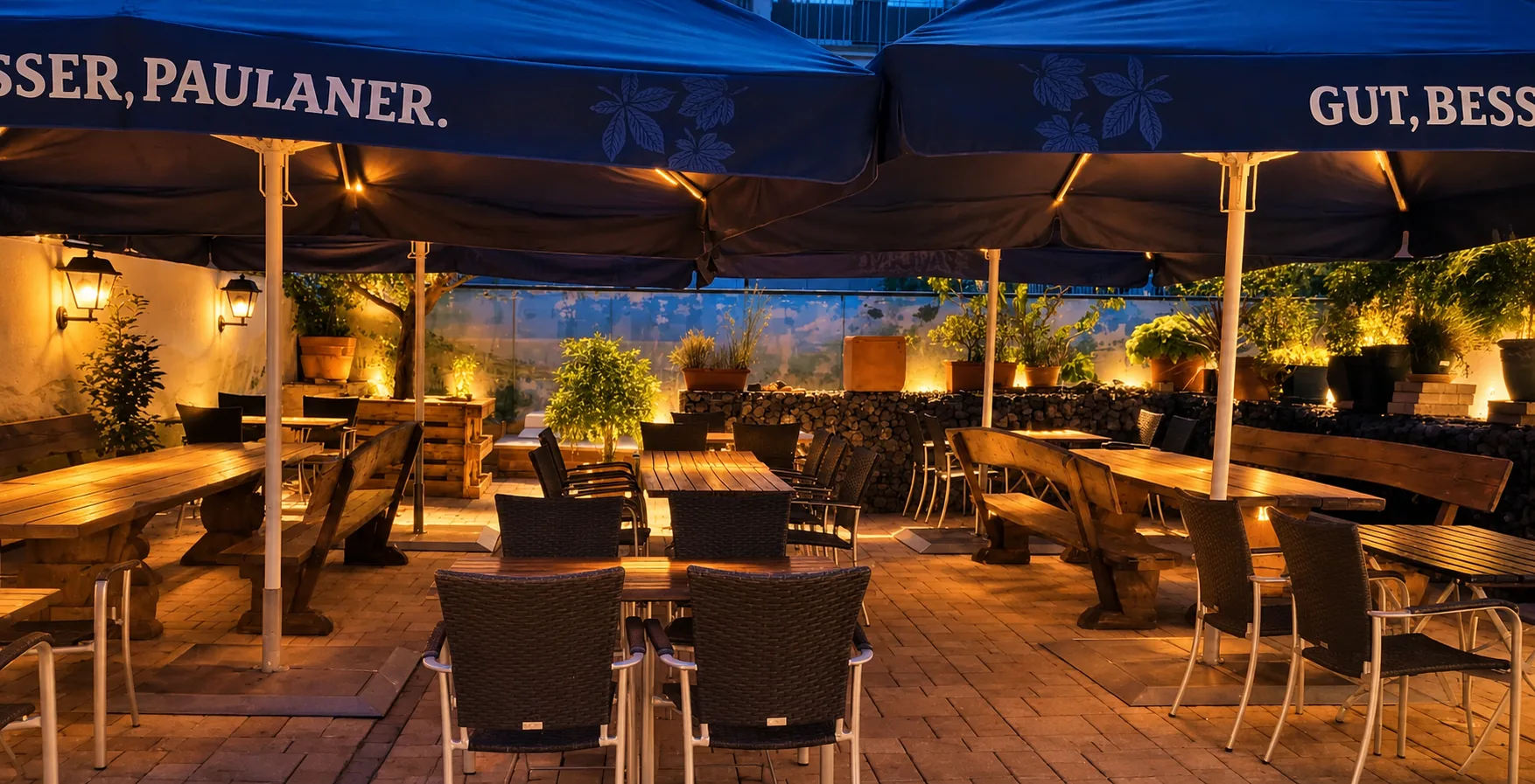 Biergarten im Hof am Abend unter blauen Schirmen